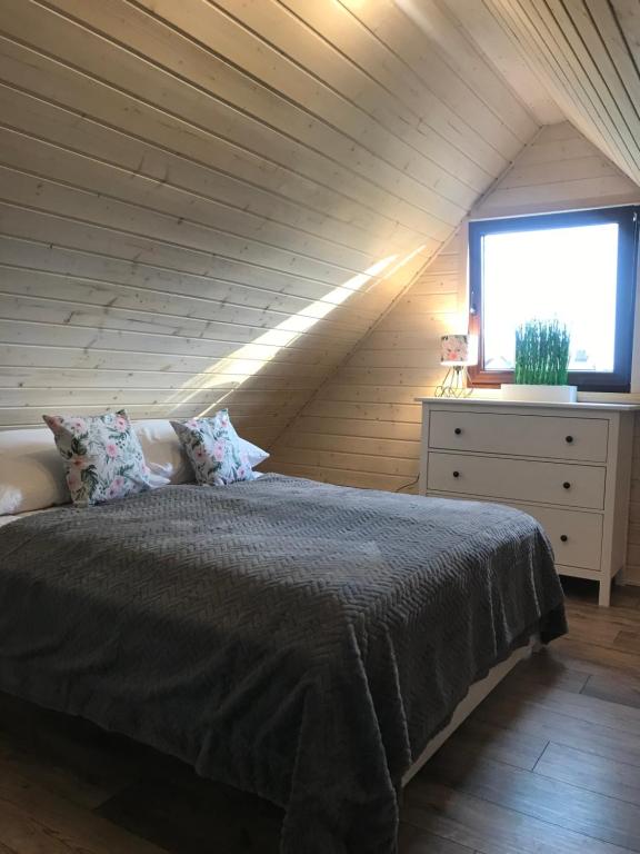 a bedroom with a bed and a window in a attic at „ Lawendowy zakątek”/„Lavender cottage” in Żywiec in Żywiec