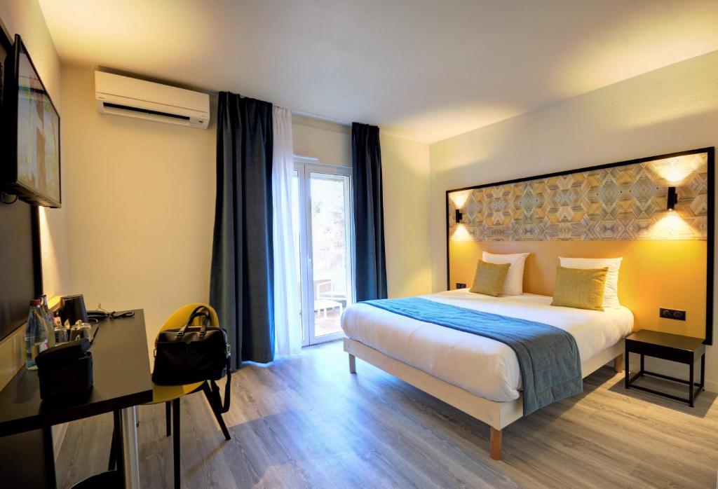 a hotel room with a bed and a window at Best Western Domaine de Roquerousse in Salon-de-Provence