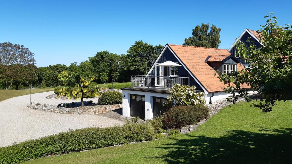 a house with a balcony on top of it at Guldkustens Gästhus - Österlen, Kivik in Kivik