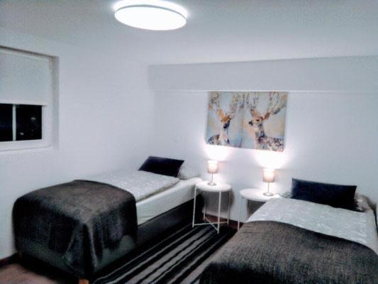 um quarto com 2 camas e uma mesa com 2 candeeiros em Ferienhaus Gemünd em Schleiden
