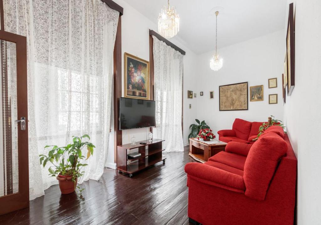 a living room with a red couch and a tv at Casa Clásica en Santa Cruz Palma in Santa Cruz de la Palma