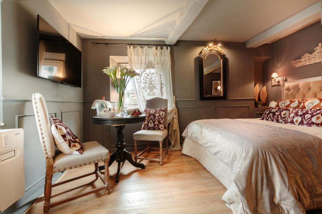 una camera da letto con un letto, un tavolo e delle sedie di The Lucca Palatial Suite a Lucca