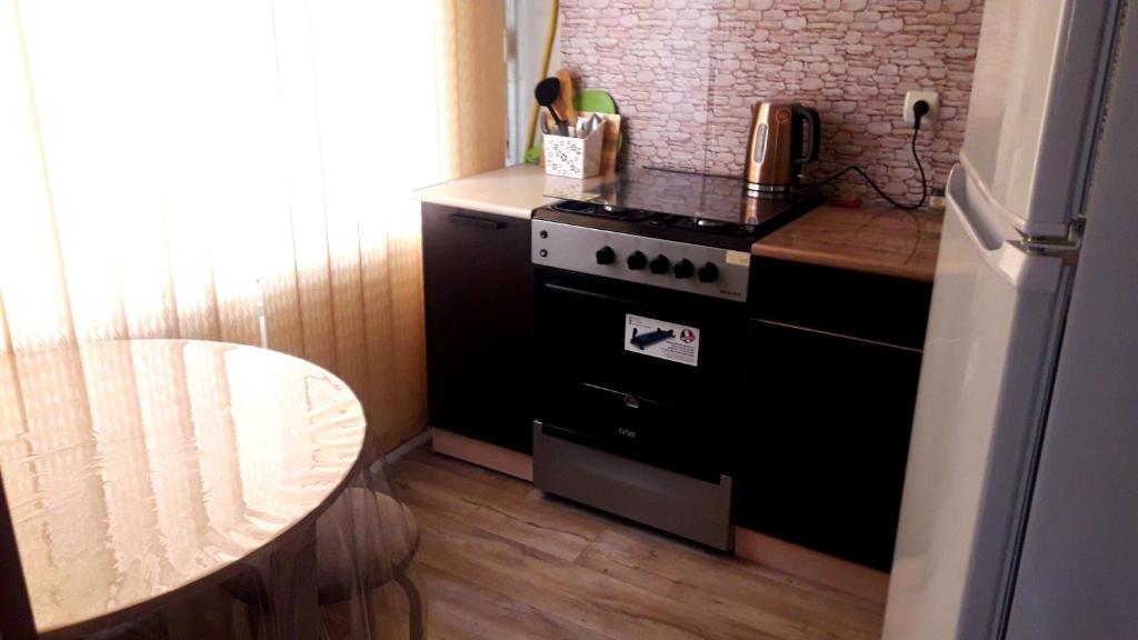 a small kitchen with a stove and a table at Квартира 5-9 in Aktau