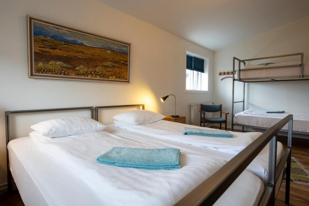 two beds in a room with two bunk beds at Sjávarborg in Stykkishólmur