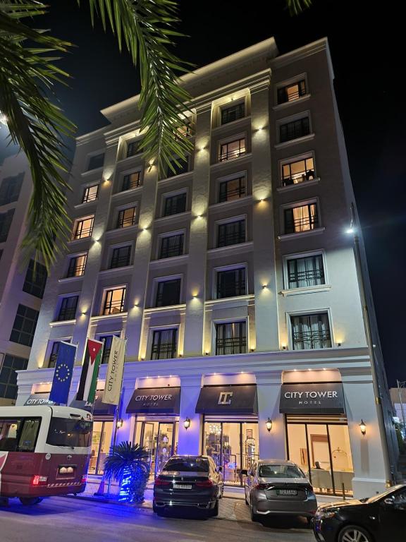 a large building with cars parked in front of it at City Tower Hotel in Aqaba