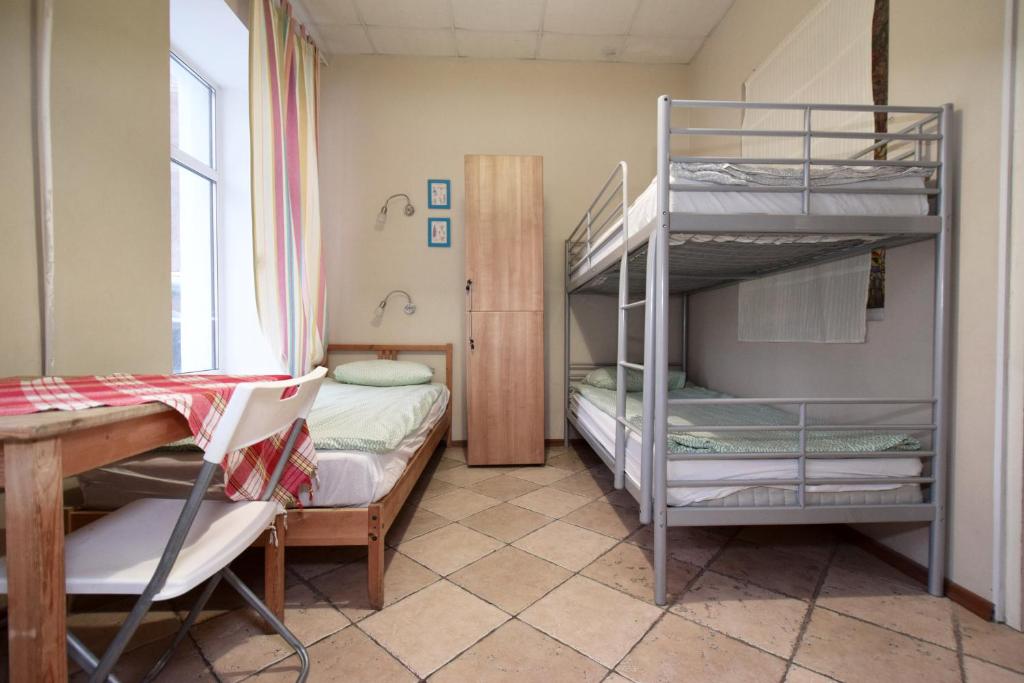 Pokój z 2 łóżkami piętrowymi, stołem i biurkiem w obiekcie Missis Hudson w Petersburgu