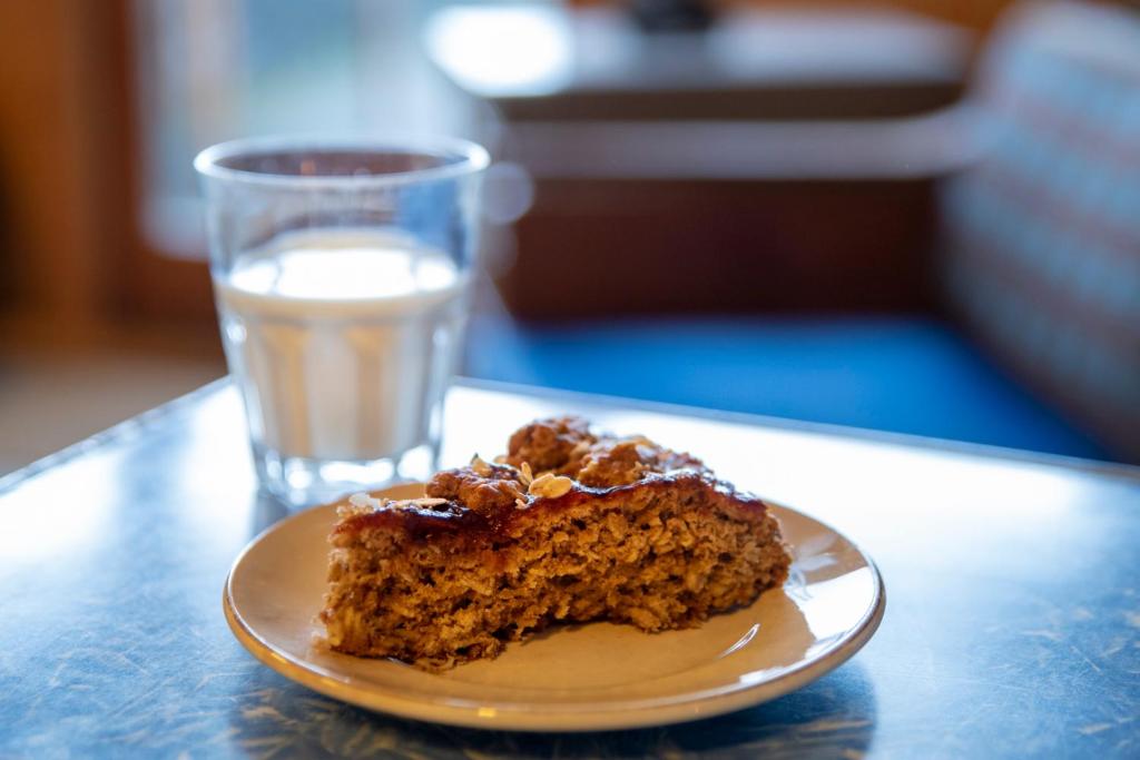 a piece of cake on a plate next to a glass of water at Sjávarborg in Stykkishólmur