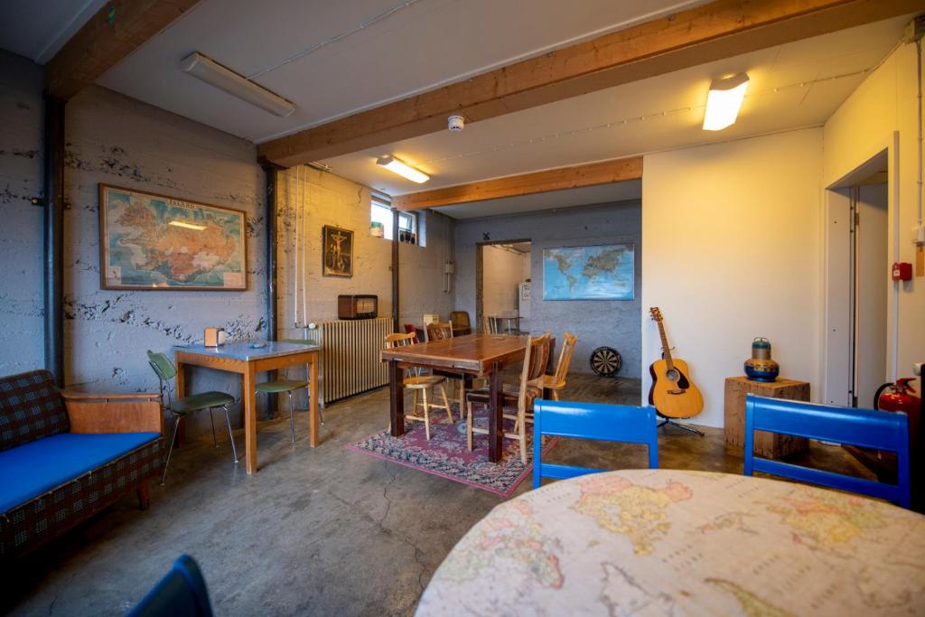 a room with tables and chairs and a guitar at Sjávarborg in Stykkishólmur