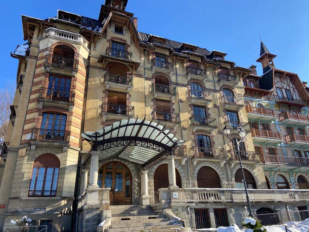 un gran edificio de piedra con una escalera delante de él en Ancient Hotel Mont Joly - 3 bedr - view - 2 bath - 80m2 en Saint-Gervais-les-Bains