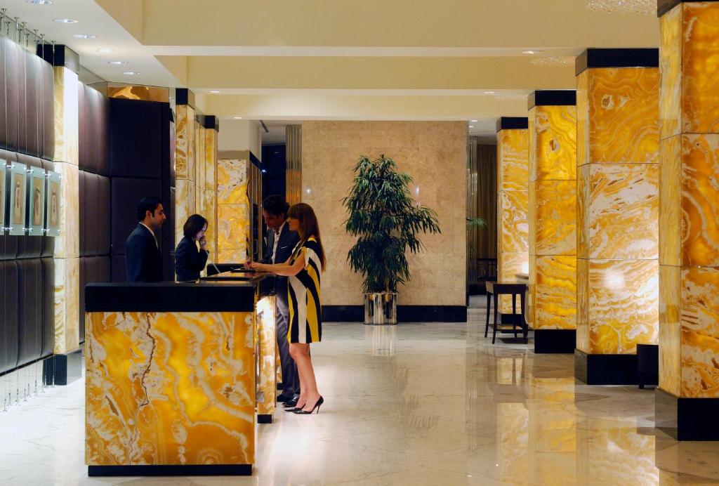 a group of people standing at a counter in a lobby at InterContinental Abu Dhabi by IHG in Abu Dhabi