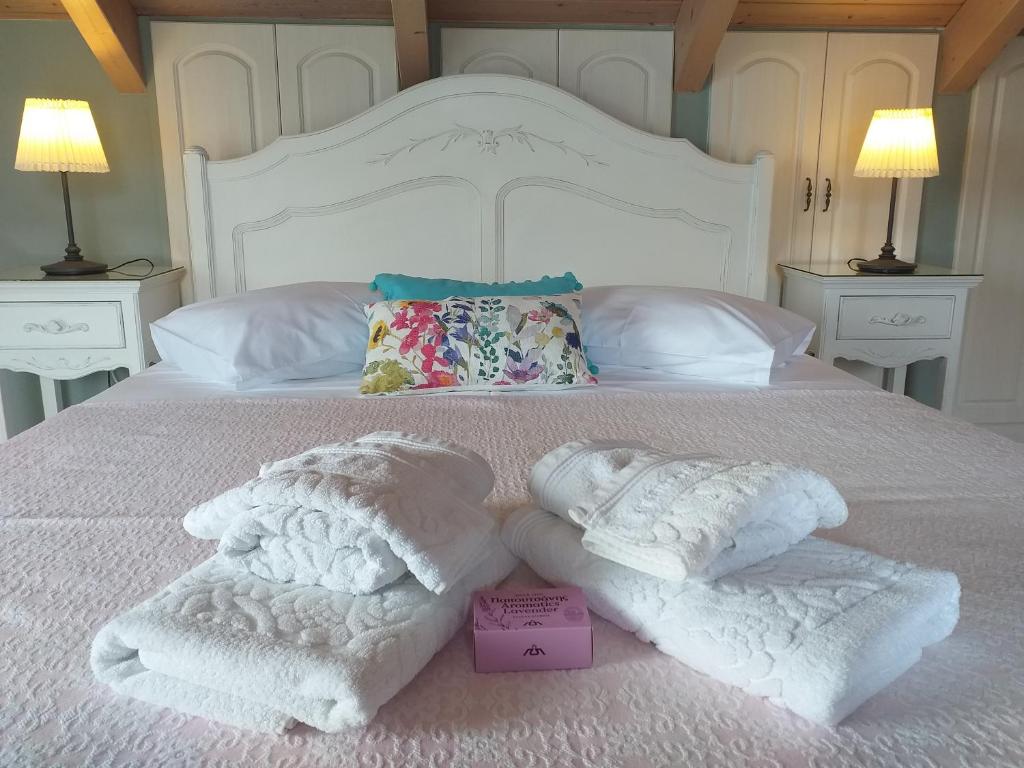 a white bed with two towels on top of it at Margarita's Attic-The Suite Loft in Spartia