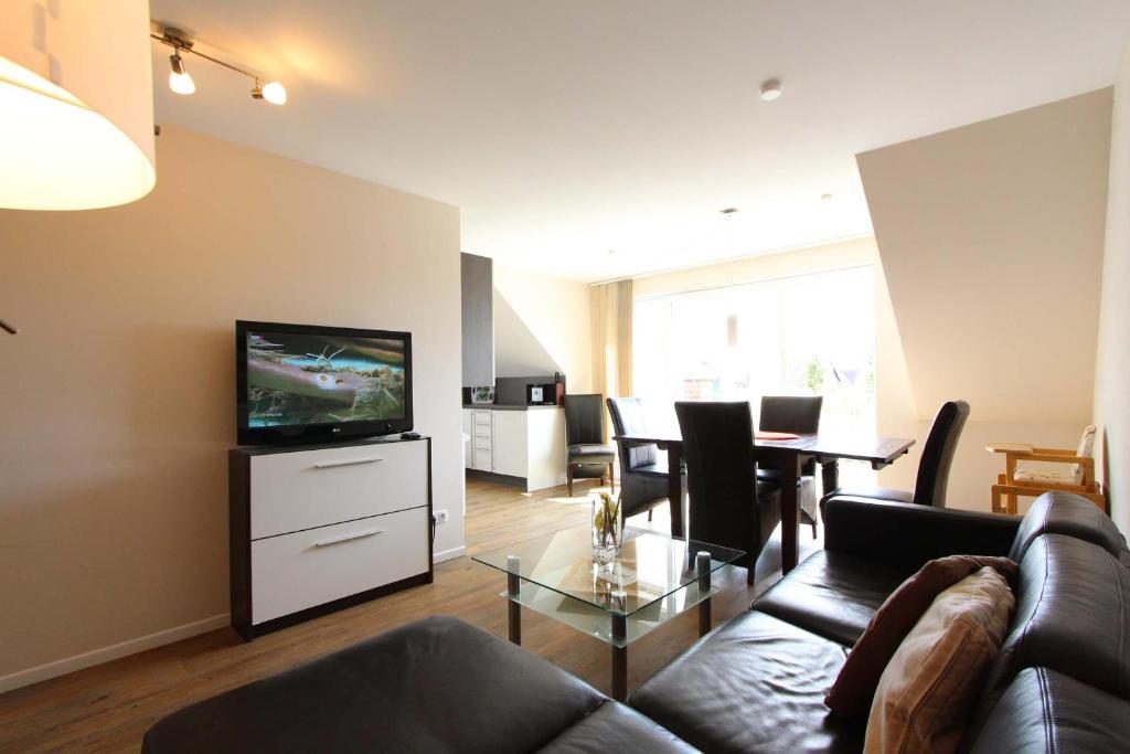 a living room with a couch and a television at Am Wintershof 5 Whg 6 in Kellenhusen