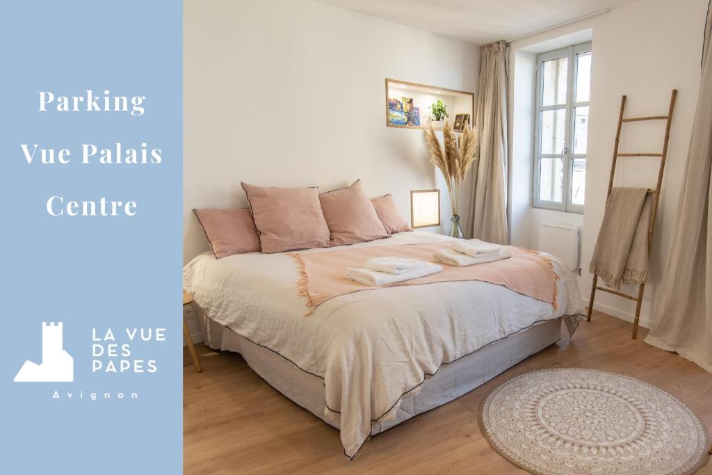 een slaapkamer met een groot bed met roze kussens bij La Vue des Papes - Hypercentre - Parking in Avignon