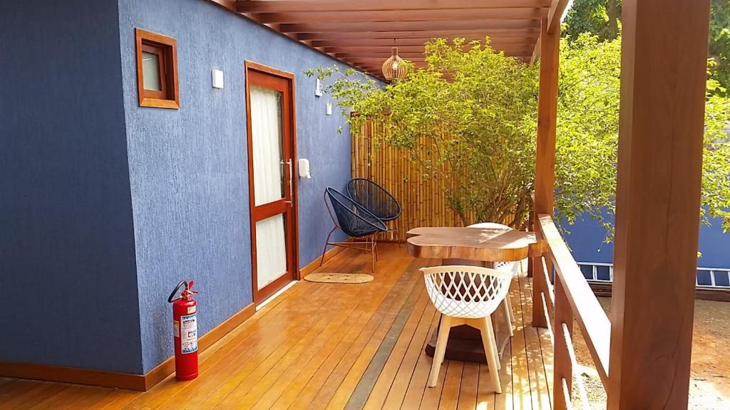 a deck with a table and a blue wall at Pousada da Mana in Fernando de Noronha