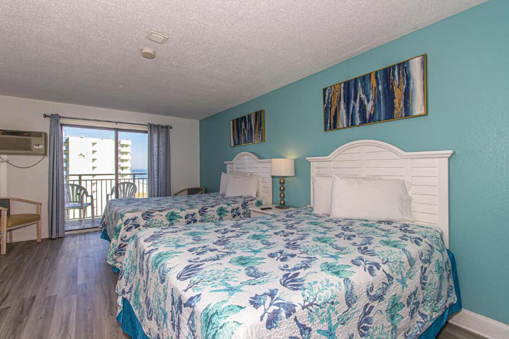 1 dormitorio con 2 camas y paredes azules en 11th Floor Suite with Incredible Views! Sea Mist Resort 51106 - 2 Double Beds - Full Kitchen!, en Myrtle Beach