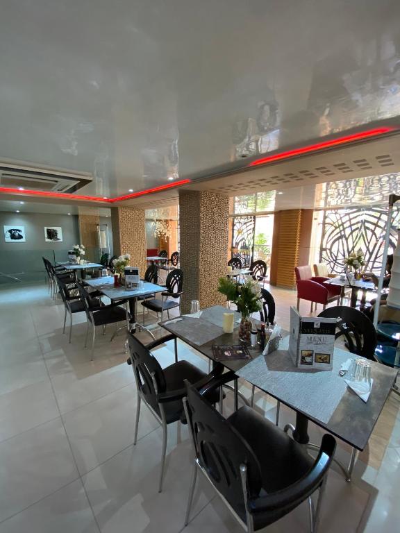a dining room with tables and chairs in a restaurant at Hotel VELSATIS in Beni Mellal