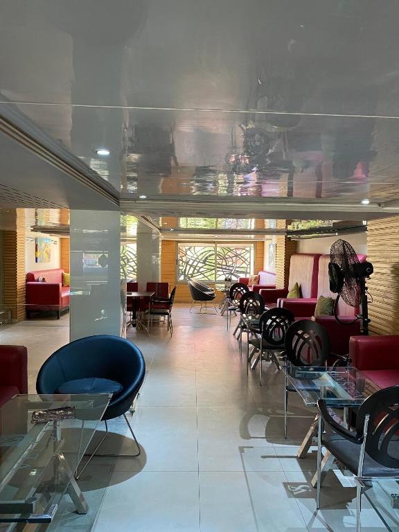 a waiting room with chairs and tables and a unintentionsenalsenalsenalsenalsenalsenal at Hotel VELSATIS in Beni Mellal