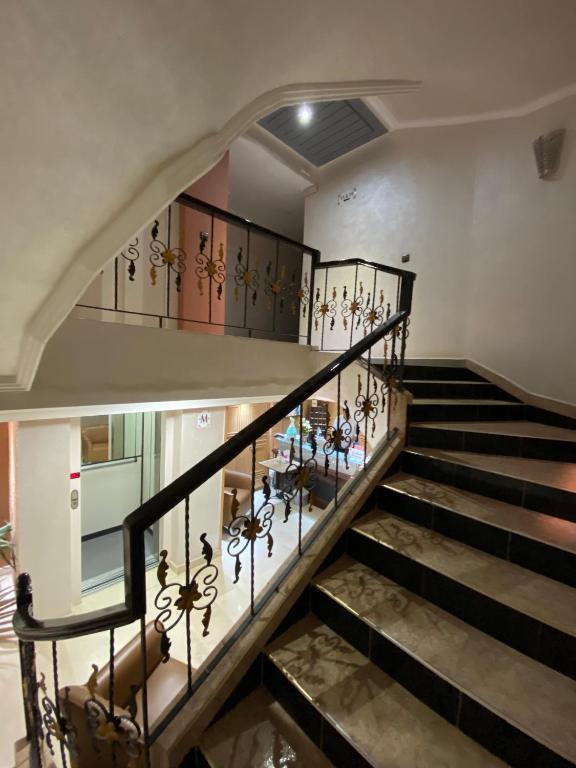 a staircase in a home with wrought iron railings at Hotel VELSATIS in Beni Mellal