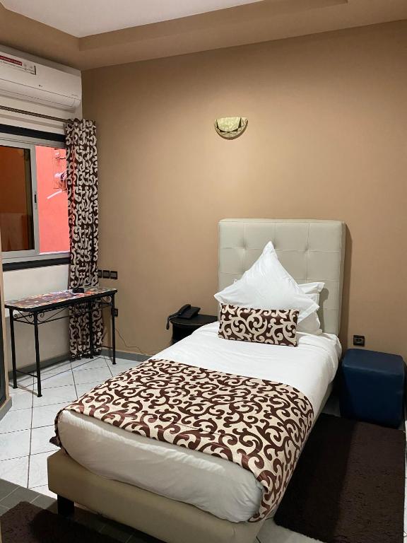 a bedroom with a large bed with pillows on it at Hotel VELSATIS in Beni Mellal