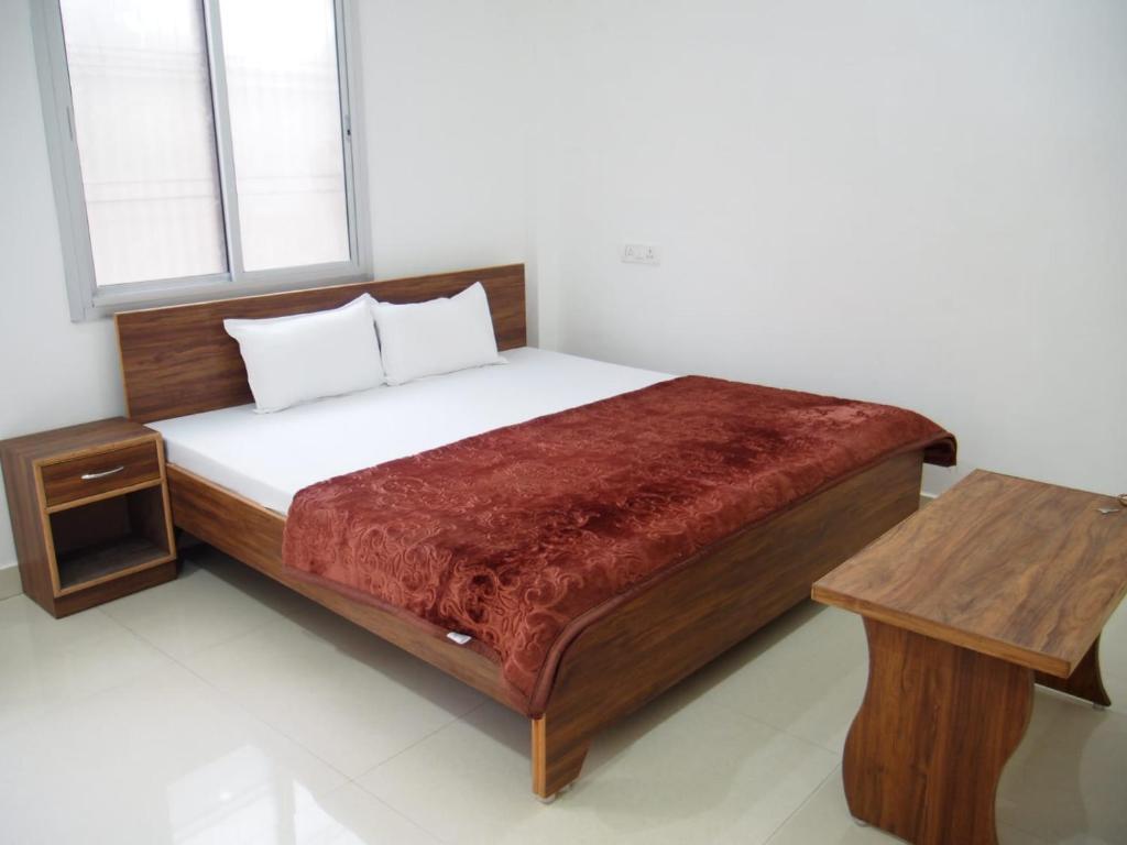 um quarto com uma cama, uma mesa e uma janela em Lotus Paying Guest house em Varanasi