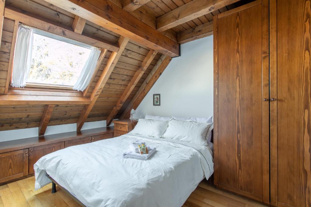 a bedroom with a large bed in a wooden cabin at Asiago Millepini - Mansarda sull'Altopiano in Asiago