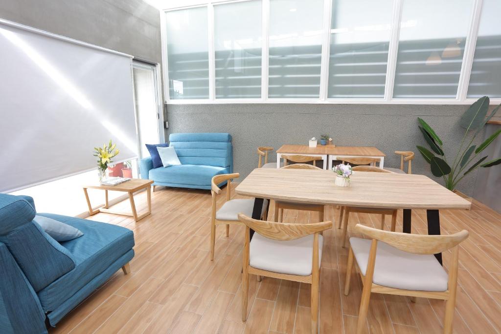 a living room with a table and a blue couch at Xiaodou B&B in Taitung City