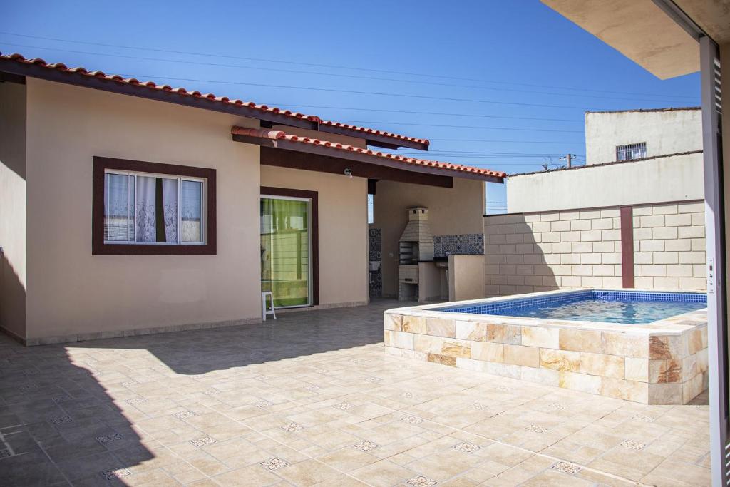 una casa con piscina en el patio trasero en Incrível casa com piscina em Itanhaém SP, en Itanhaém
