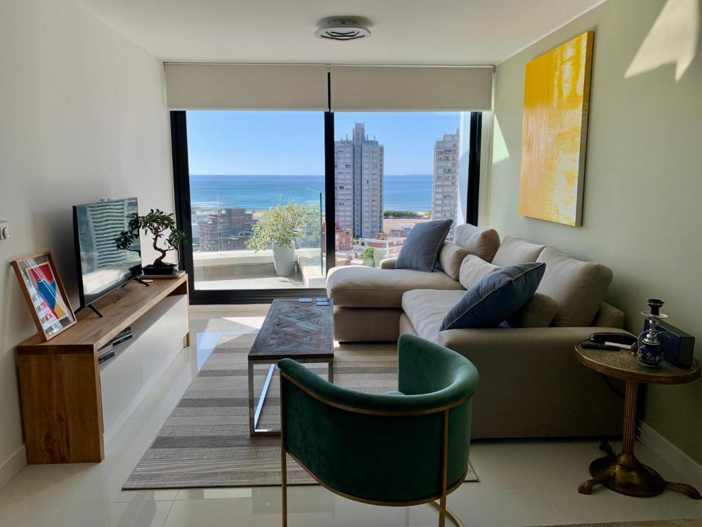 sala de estar con sofá y TV en ARTOWER - Ocean View 1 bedroom apartment, en Punta del Este