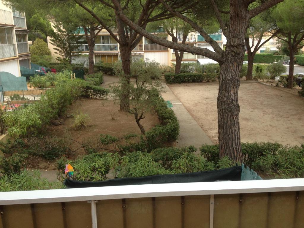 a view of a park from a balcony with a tree at CAP D&#39;AGDE studio cabine 6 pers. + terrasse + parking privé + clim (calme) in Cap d&#39;Agde