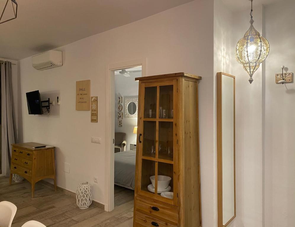 a room with a wooden cabinet and a bedroom at Benal Beach Apartments in Benalmádena