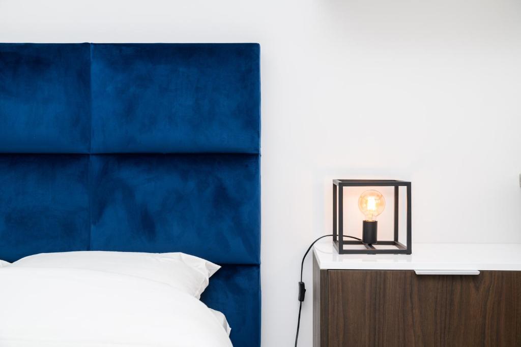 een slaapkamer met een bed en een blauw hoofdeinde bij The City Nest - Duke Housing in Créteil