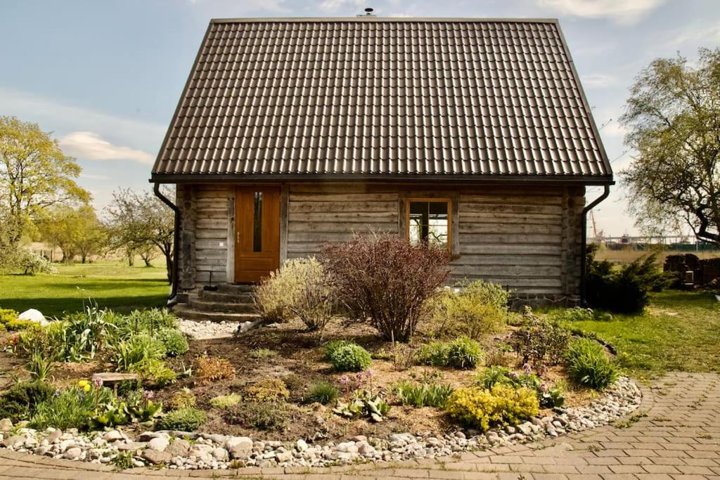 una pequeña casa con un jardín frente a ella en Rīga Mangalsala Cottage with sauna, en Riga