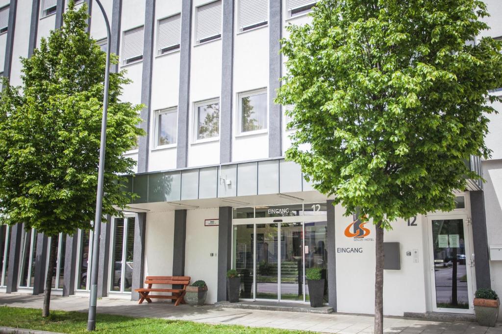 ein Bürogebäude mit Bäumen davor in der Unterkunft GS Hotel in München