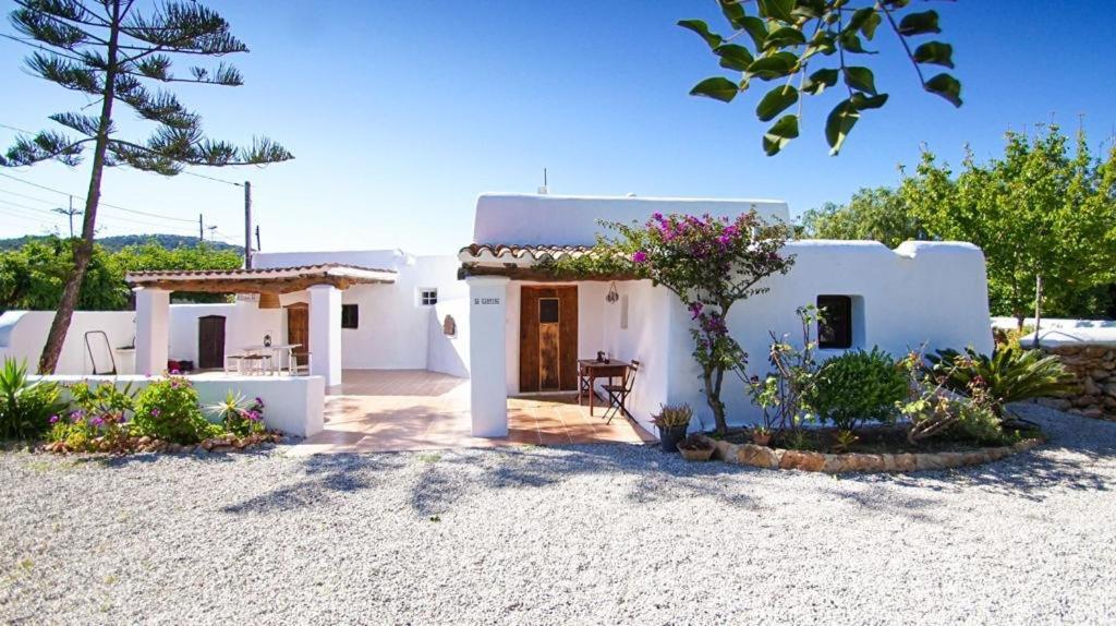 una pequeña casa blanca con una mesa delante en FINCA RELAX IBIZA STILE en San José