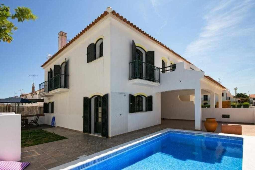 uma casa com uma piscina em frente em Vila com piscina e jardim privado em Altura