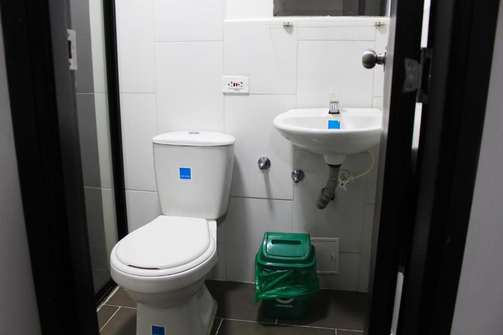 a bathroom with a toilet and a sink at Hotel America 52 in Rionegro