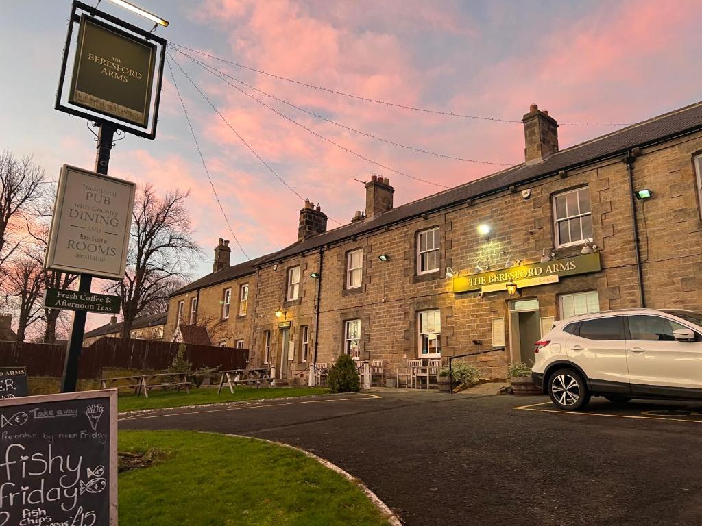 um carro estacionado num parque de estacionamento em frente a um edifício em The Beresford Arms em Morpeth