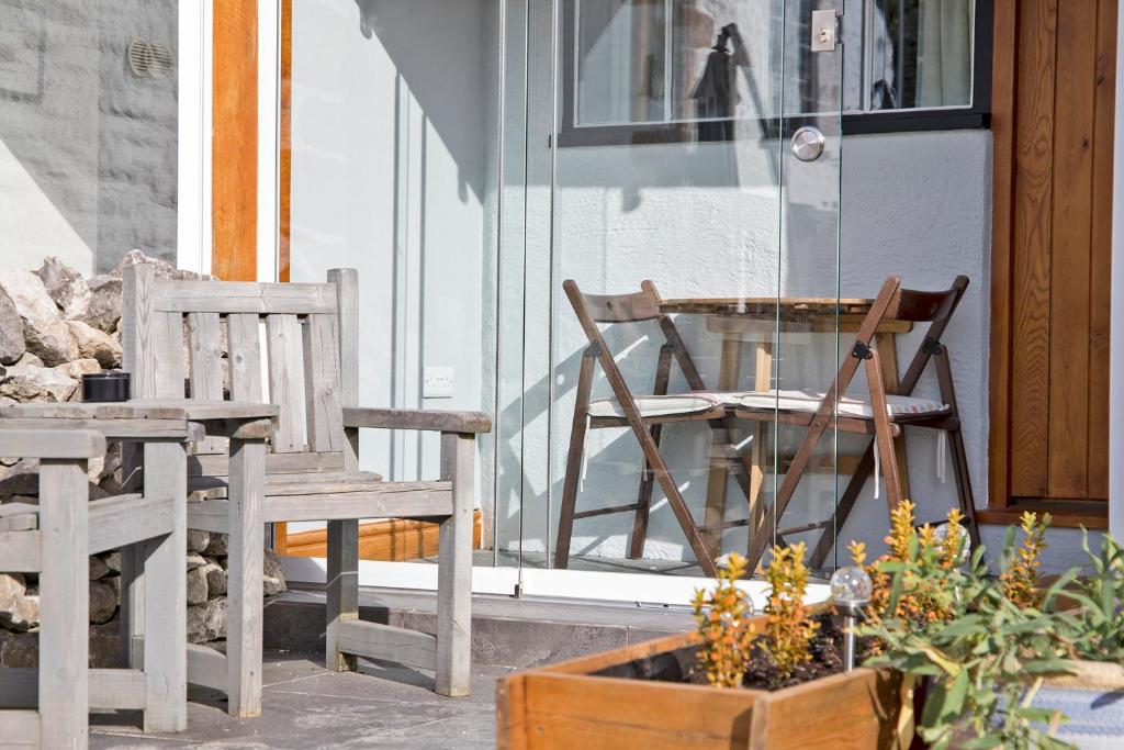 two chairs and a table and a table and chairs on a porch at Hawthorn Farm Guest House in Buxton
