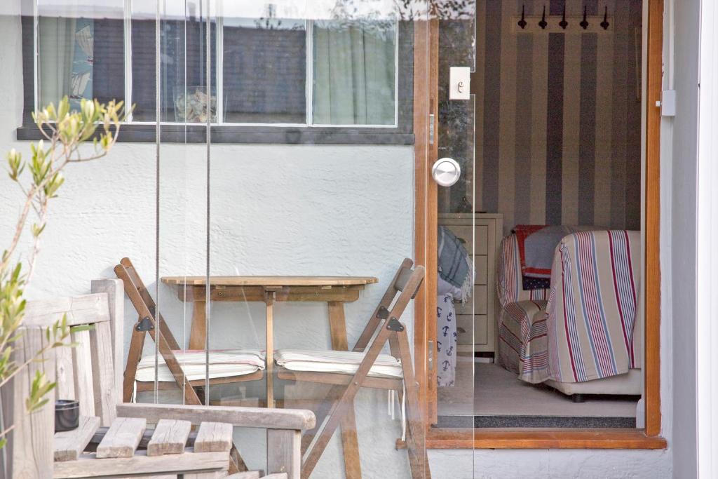 a porch with a swing and a table and chairs at Hawthorn Farm Guest House in Buxton