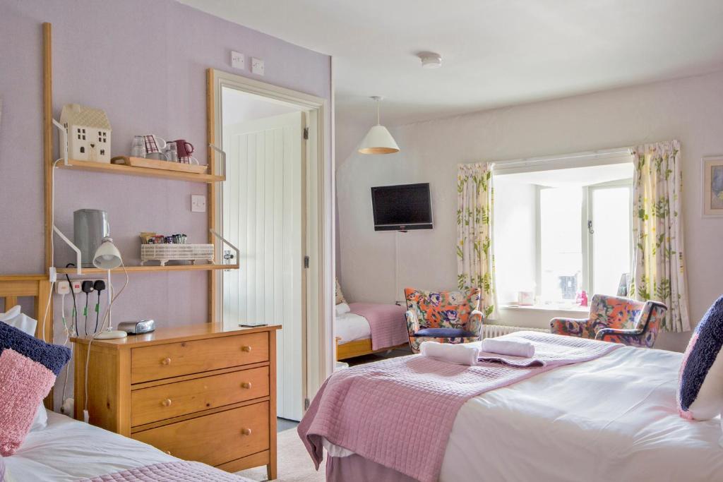 a bedroom with a bed and a dresser and a mirror at Hawthorn Farm Guest House in Buxton