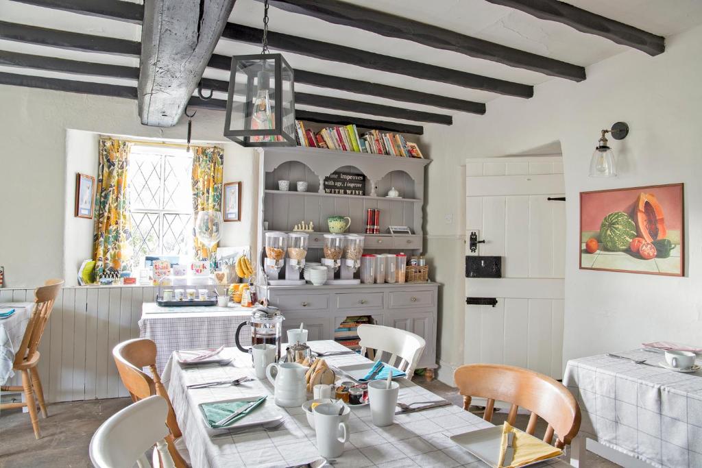 a dining room with a table and chairs and a kitchen at Hawthorn Farm Guest House in Buxton