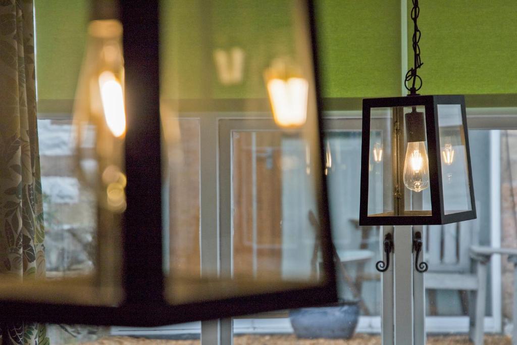 a chandelier is hanging in front of a window at Hawthorn Farm Guest House in Buxton