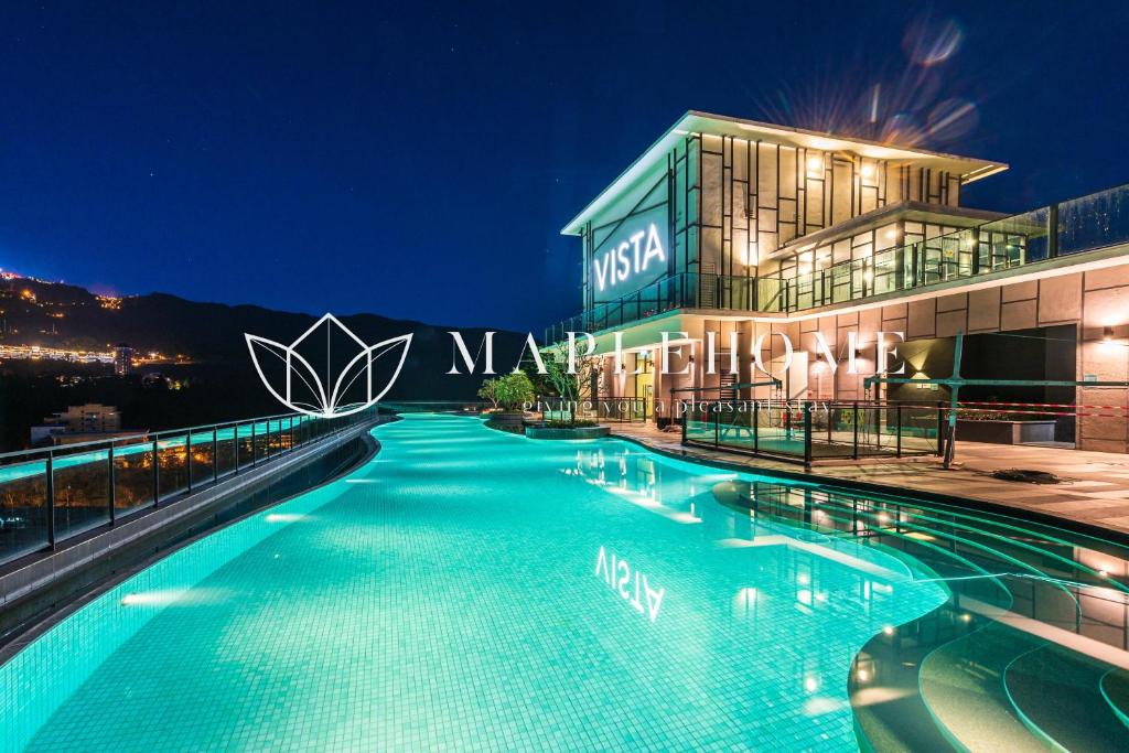 Vista Premier Suites Genting Highlands في مرتفعات جنتنغ: مسبح امام مبنى في الليل