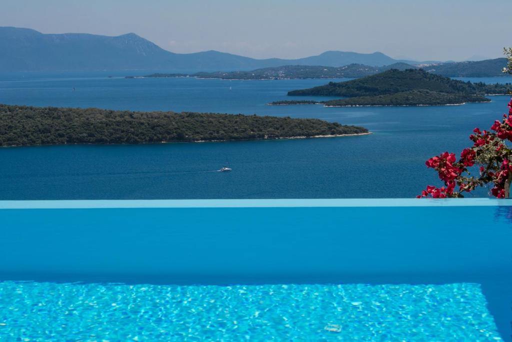 dwa widoki na jezioro z łodzią w wodzie w obiekcie Villa Pasithea - breathtaking seaviews, infinity pool, privacy, close to the beach w mieście Nydri