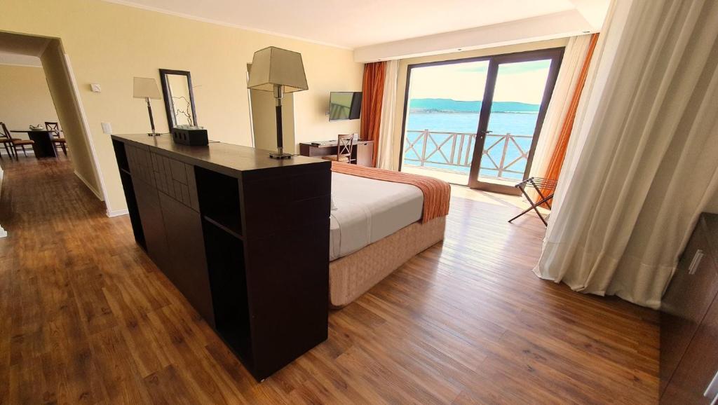 a bedroom with a bed and a view of the ocean at Xelena Hotel & Suites in El Calafate