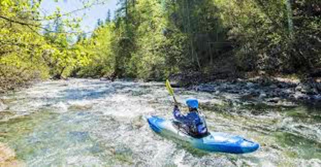 a person in a blue kayak in a river at Studio avec jardin clos et wifi a La Salle les Alpes in La Salle-les-Alpes