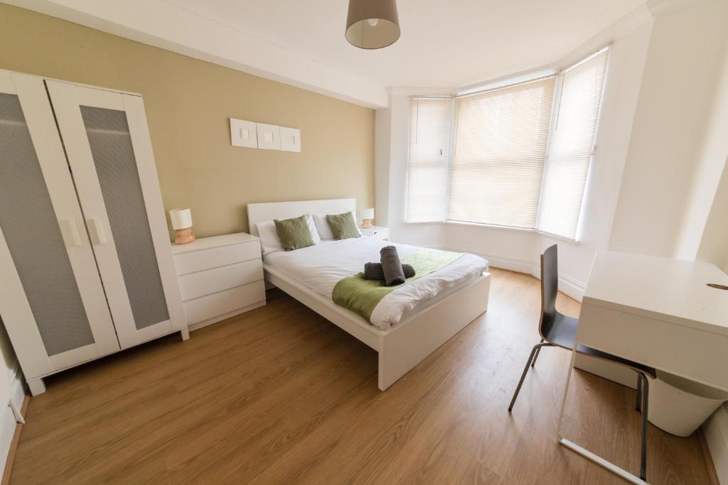 a bedroom with a bed and a desk and a table at Modern and Spacious House Perfect for Teams in Luton