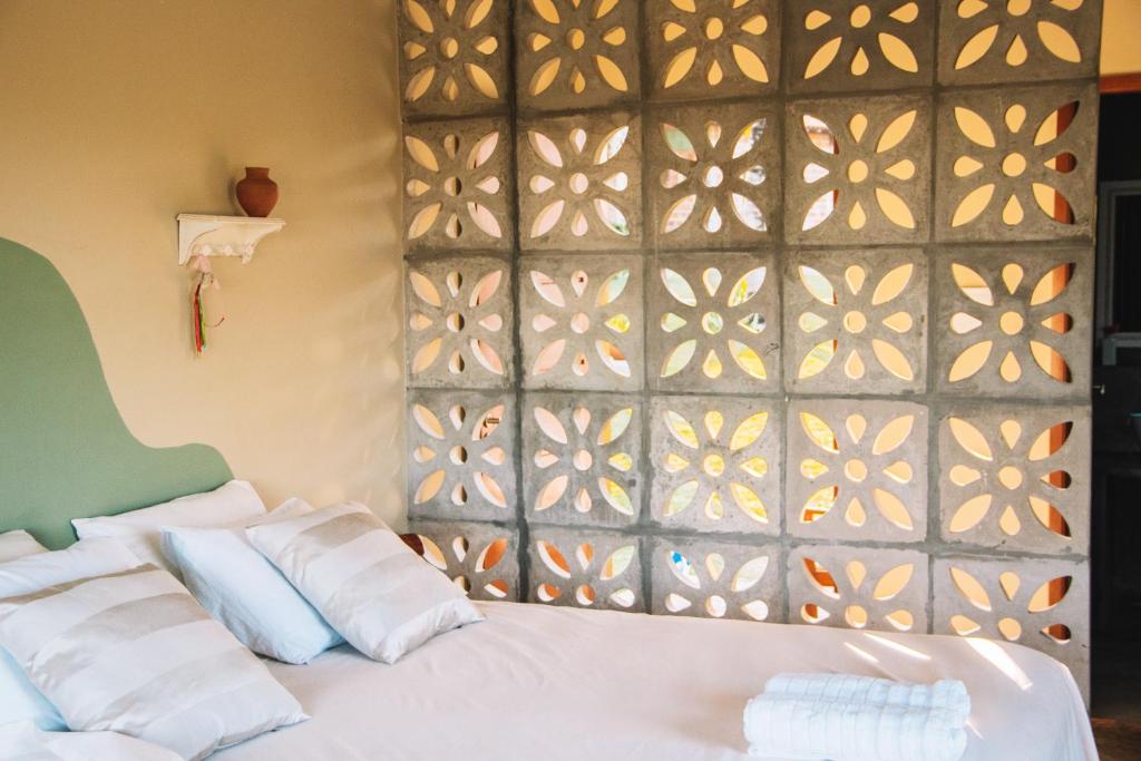 een slaapkamer met een wit bed en een muur bij Quintal de Areias in Santo Amaro