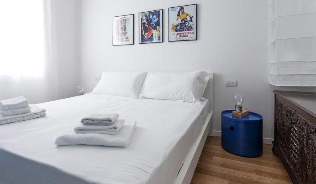 ein Schlafzimmer mit einem weißen Bett und Handtüchern darauf in der Unterkunft Navigli Suites - De Santis in Mailand