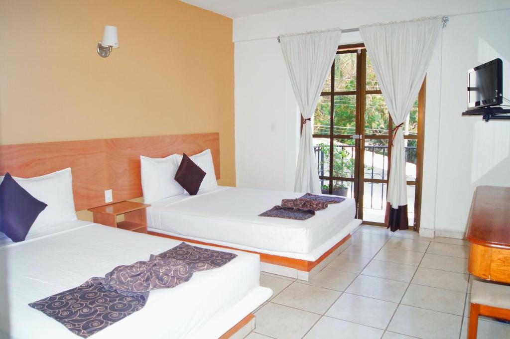 Habitación de hotel con 2 camas y TV en AM Amakal Hotel & Park, en Santa Cruz Huatulco